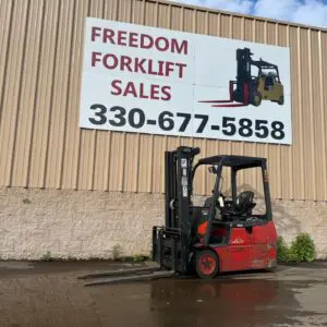 Red forklift in front of sales sign.