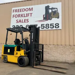 Yellow forklift parked outside sales building.