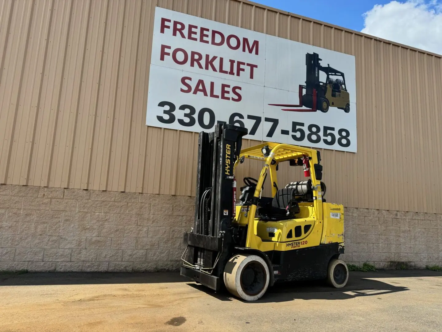 Yellow forklift outside sales building.