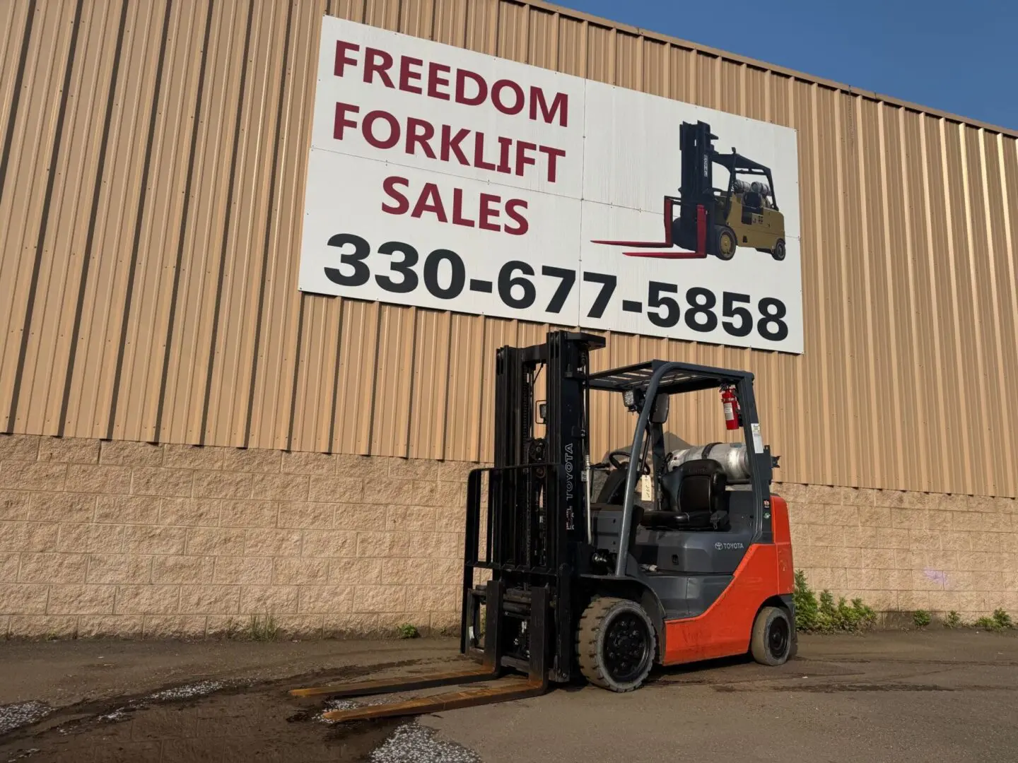 Forklift parked near sales company sign. Forklift parked near sales company sign.