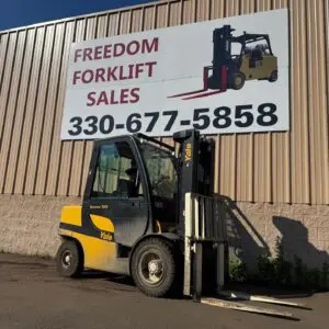 Forklift parked under sales sign.